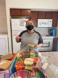 A woman making healthy eating choices pictures with a tray of vegetables.