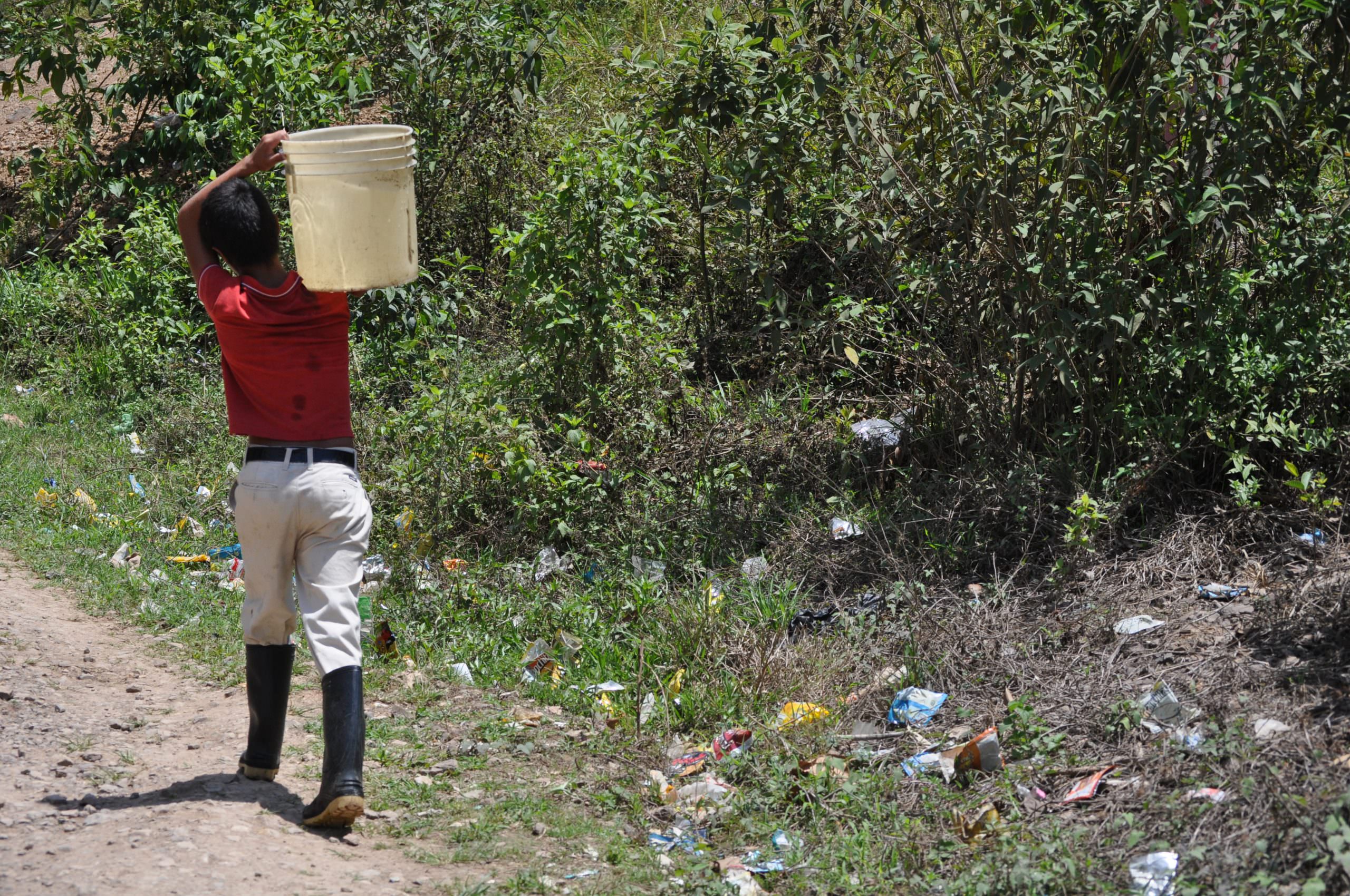 Red shirt boy carrying water scaled