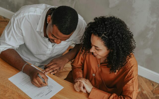 Make transformational gifts A young couple signing a legacy planning document to Advance Community